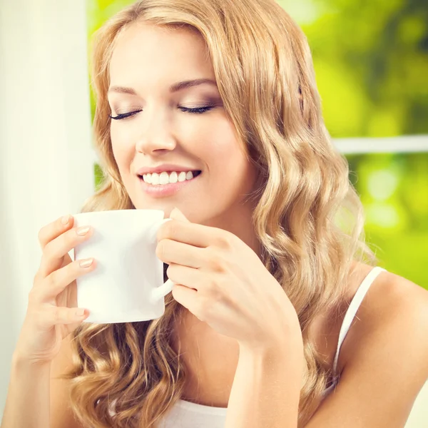 Jonge vrouw drinken koffie of thee, thuis — Stockfoto