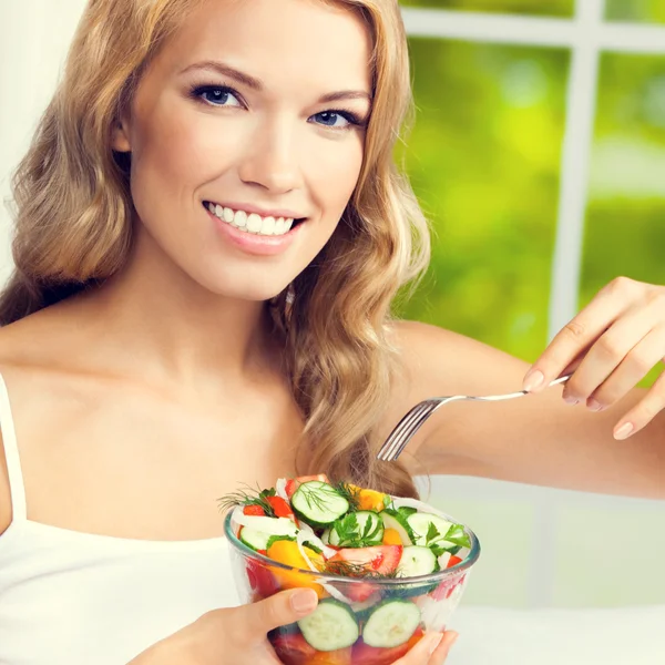 Femme mangeant une salade, à l'intérieur — Photo