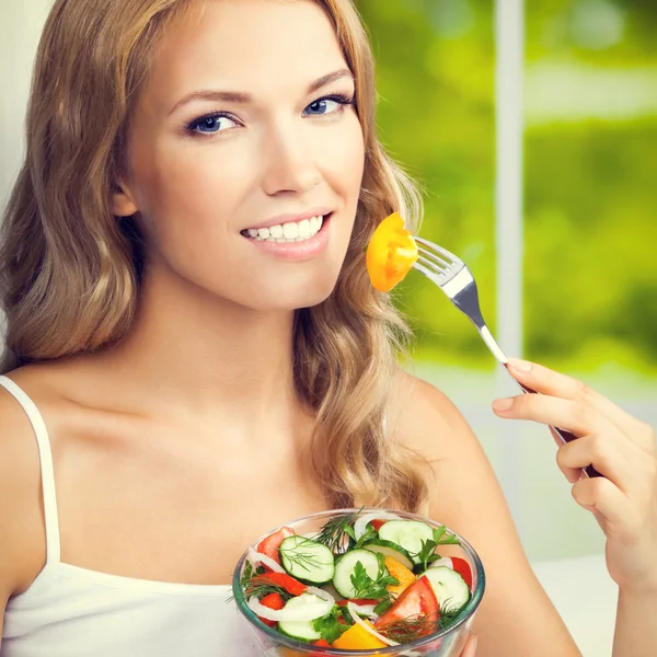 Mujer comiendo ensalada, adentro — Foto de Stock