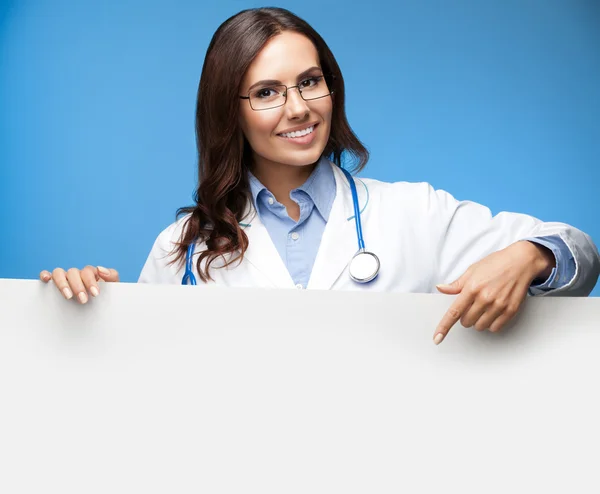 Doctora mostrando letrero en blanco, sobre azul — Foto de Stock