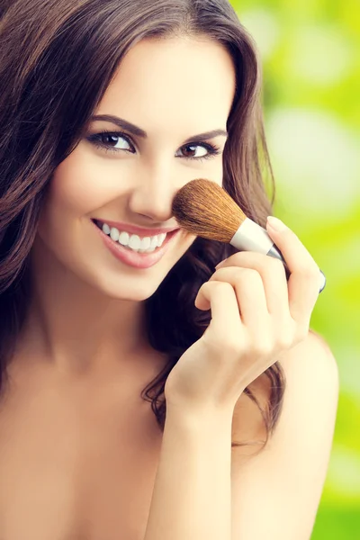 Mujer joven con cepillo de maquillaje — Foto de Stock