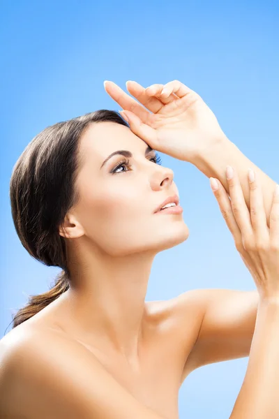 Portrait of woman with naked shoulders, on blue — Stock Photo, Image