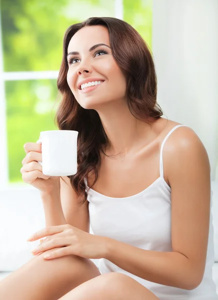Kvinna som dricker kaffe eller te, hemma — Stockfoto