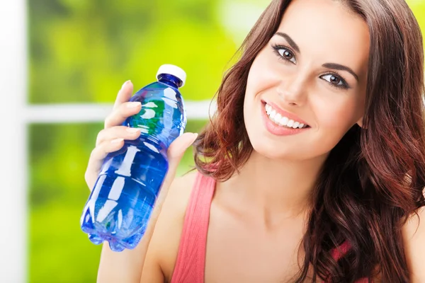 Glad ung kvinna med en flaska vatten — Stockfoto