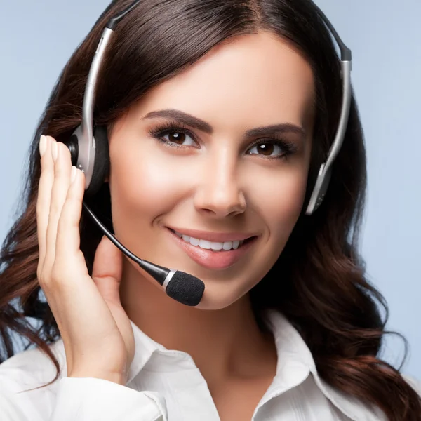 Retrato de sonriente soporte operador de telefonía femenina en auriculares — Foto de Stock