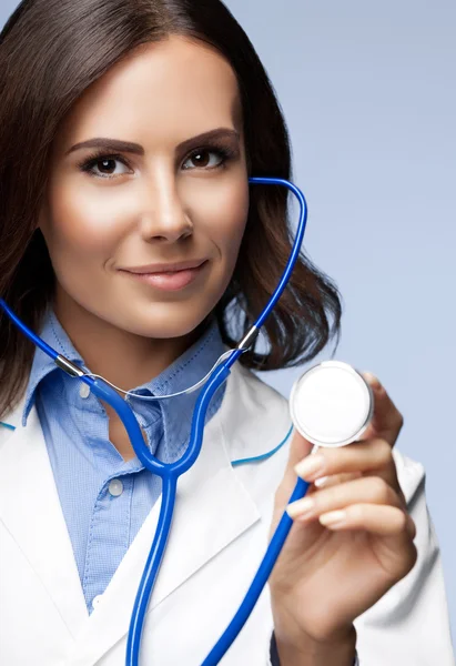 Médico con estetoscopio en la mano, en gris — Foto de Stock