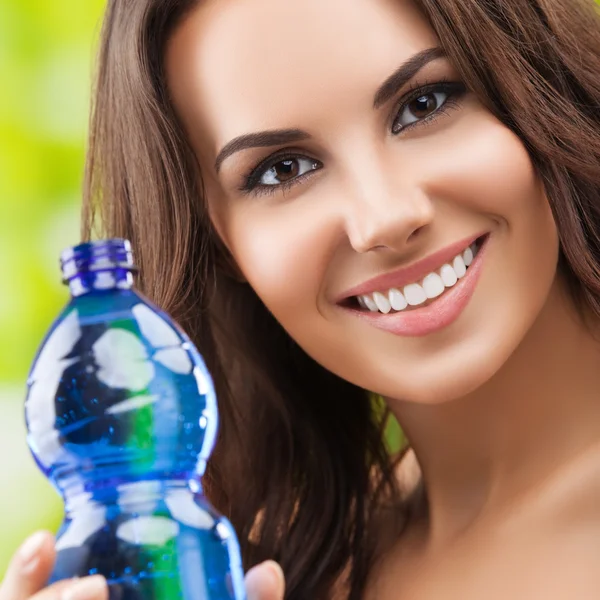 Jeune femme montrant bouteille d'eau — Photo