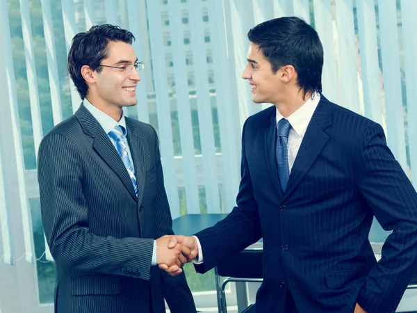 Dos empresarios animando con apretón de manos en la oficina — Foto de Stock