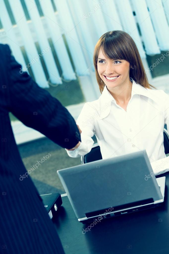 Two businesspeople cheering by handshake at office