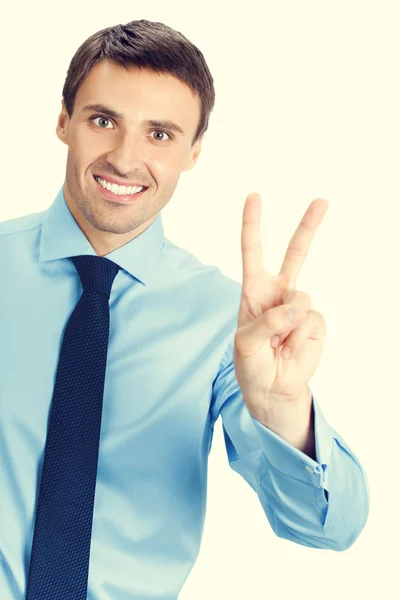 Feliz joven hombre de negocios sonriente mostrando dos dedos o victoria — Foto de Stock