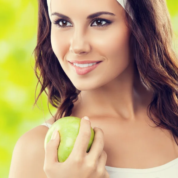 Joven mujer feliz en ropa deportiva con manzana verde, al aire libre —  Fotos de Stock