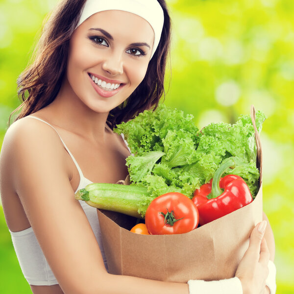 smiling woman in fitness wear with vegetarian food
