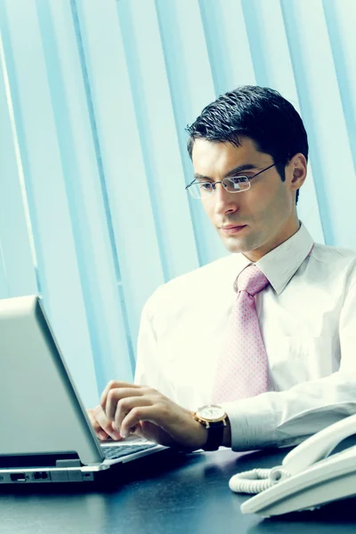 Бизнесмен с ноутбуком в офисе — стоковое фото