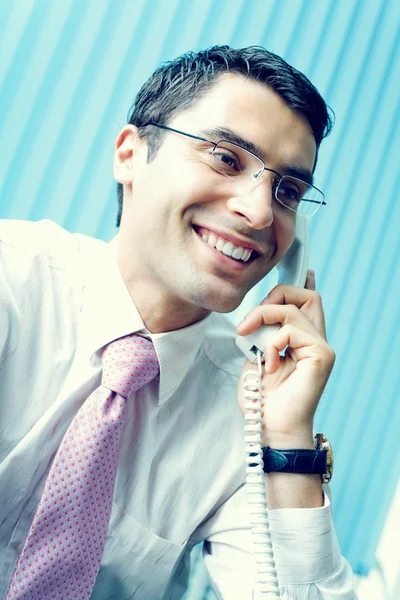 Ofisinde telefonu olan bir iş adamı.