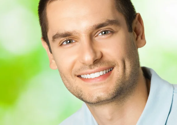 Bonito jovem sorridente homem, ao ar livre — Fotografia de Stock