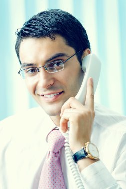 Ofisinde telefonu olan bir iş adamı.