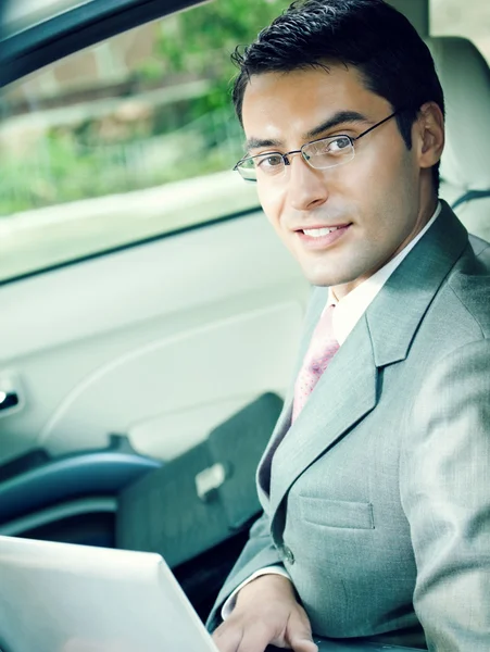 Portrait d'homme d'affaires avec ordinateur portable en voiture — Photo