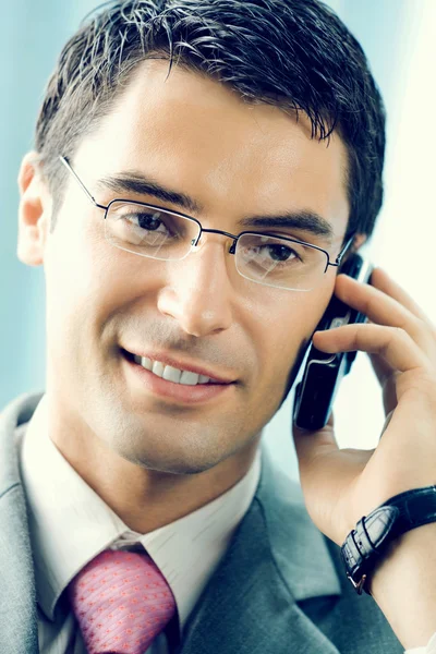 Uomo d'affari con cellulare in ufficio — Foto Stock