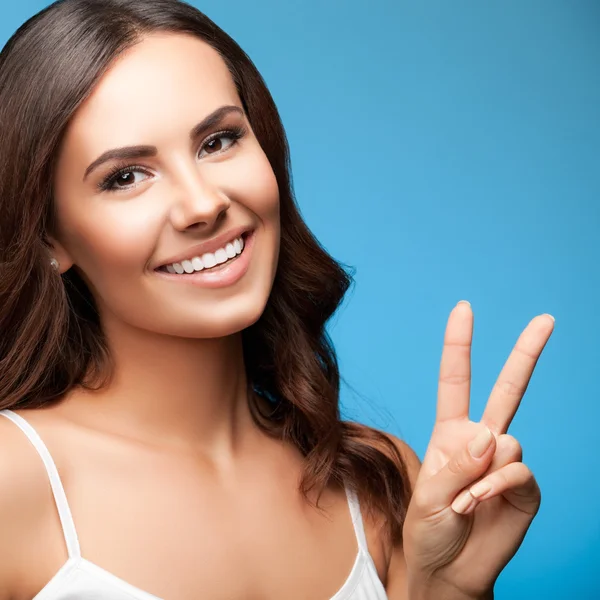 Mujer mostrando dos dedos o gesto de victoria, en azul — Foto de Stock