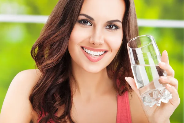 Junge glückliche Frau mit einem Glas Wasser — Stockfoto