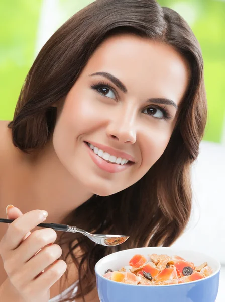 Vrolijke mooie jonge vrouw eten mousseline — Stockfoto