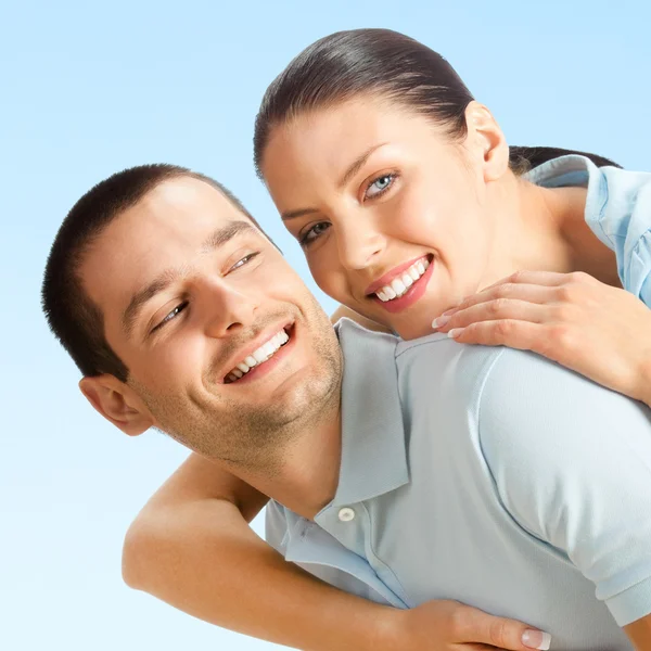 Young happy smiling amorous attractive couple, on blue sky — Stock Photo, Image