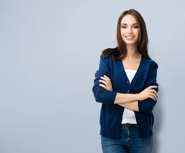 Smiling young woman with crossed arms, with copyspace — Stock fotografie