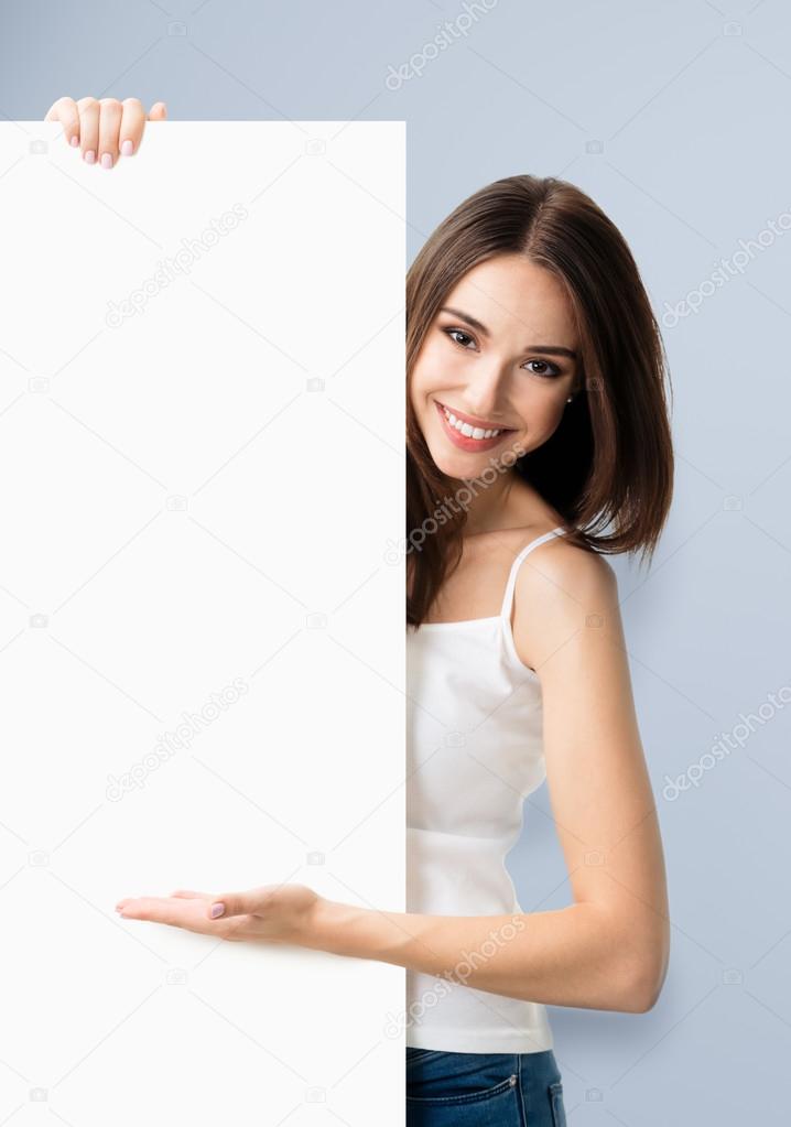 Brunette woman in casual clothing showing blank signboard