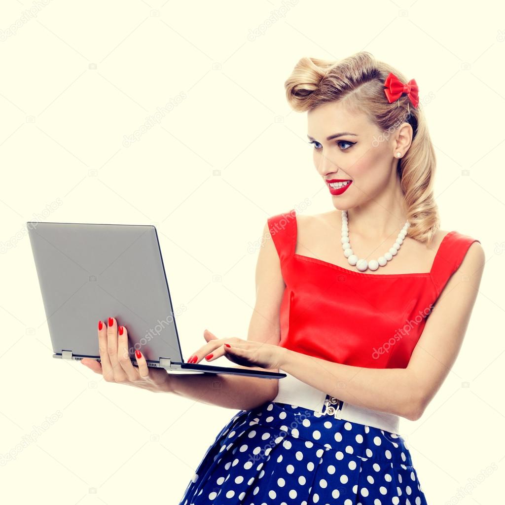 woman holding laptop, dressed in pin-up style dress