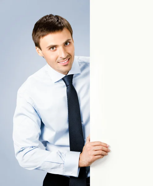 Hombre de negocios mostrando letrero en blanco, sobre gris — Foto de Stock