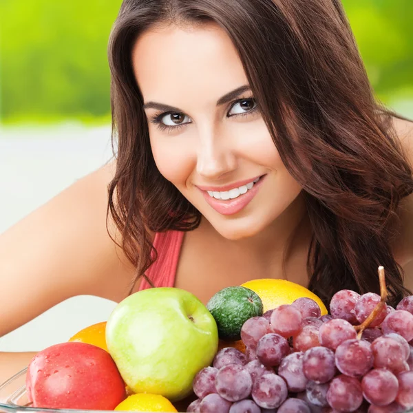 Femme souriante avec assiette de fruits — Photo