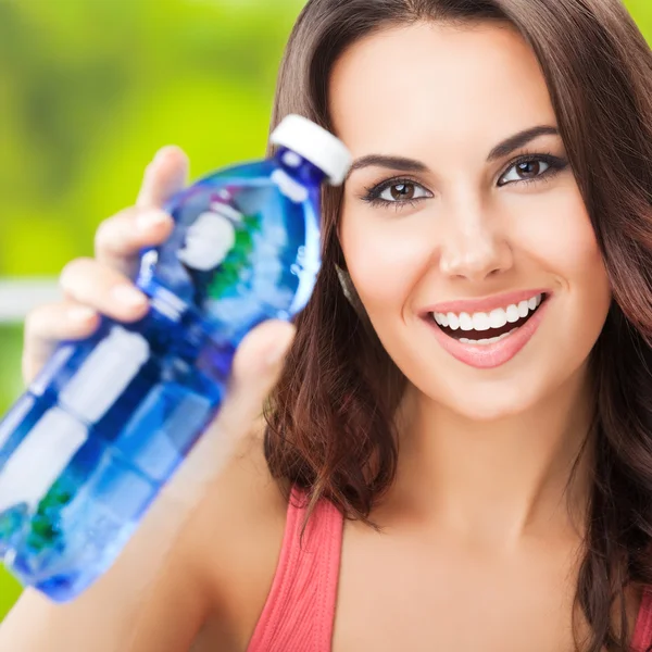 Portret van vrolijke jonge vrouw met fles water — Stockfoto