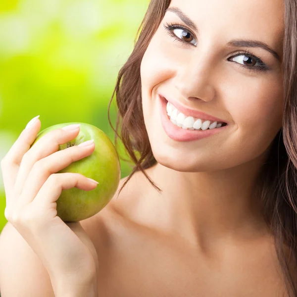 Young happy smiling woman with apple, outdoors — Stock Photo, Image