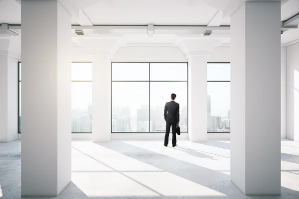 Geschäftsmann steht in leerem Büro — Stockfoto