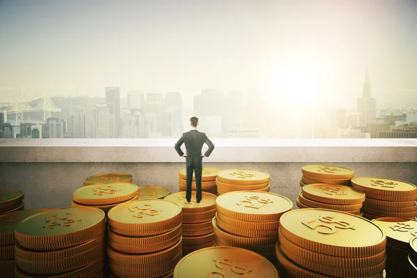 Empresário em pé sobre moedas de ouro — Fotografia de Stock