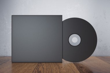 Boş siyah kompakt disk ahşap masa ve beton duvar arka kapağında. Alay etmek yukarıya, 3d render
