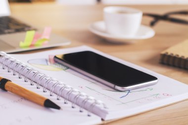 Telefon ve kalem not defteri üzerinde