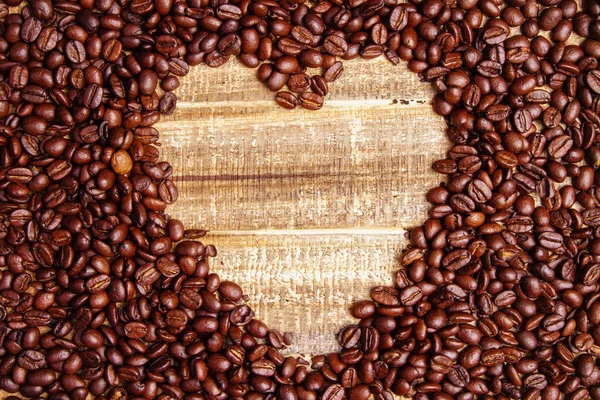 Topview de coração de semente de café na mesa de madeira — Fotografia de Stock