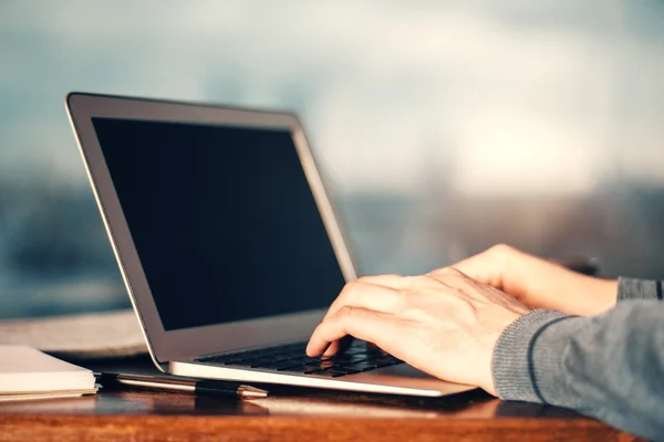 Człowiek z rękawem szara wpisując na klawiaturze laptopa — Zdjęcie stockowe