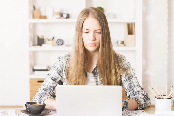 Framifrån av attraktiva kaukasiska flicka med laptop i kontor med shleves i bakgrunden — Stockfoto