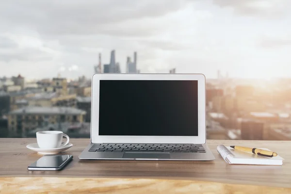 Laptop em branco no fundo da cidade — Fotografia de Stock