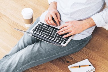 Genç erkek dizüstü kat kullanarak