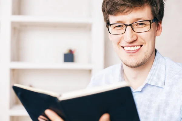 Uomo sorridente libro in mano — Foto Stock