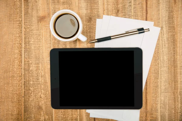 Svart pad skärm på träbord med kaffe, ark och penna. Topview, håna upp — Stockfoto