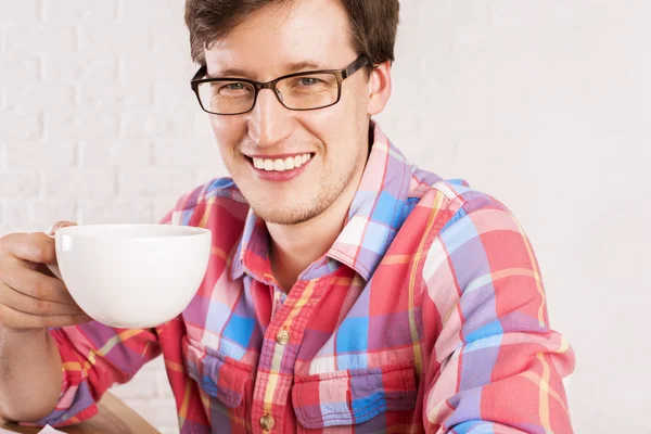Улыбающийся человек с чашкой кофе — стоковое фото
