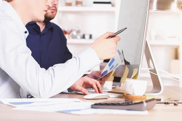 Männer diskutieren Diagramme Seite — Stockfoto