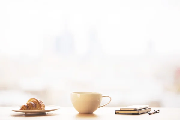 Taza de café, croissant y teléfono — Foto de Stock