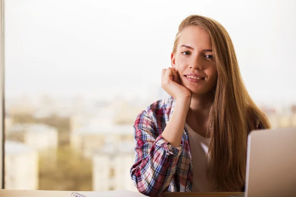 Lächelnde junge Frau am Schreibtisch — Stockfoto
