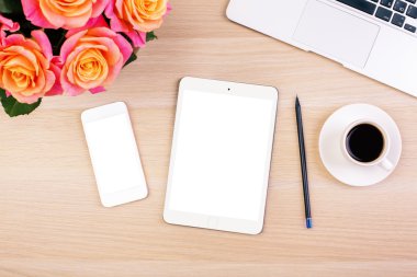 Gül, boş beyaz akıllı telefon ve tablet ekranları, kahve Kupası, kalem ve dizüstü klavye ile yaratıcı kadının masaüstünün Üstten Görünüm.