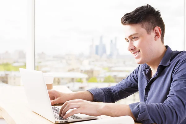 Smiling man using laptop side — Stock Photo, Image